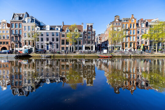 Netherlands, North Holland, Amsterdam, Rowhouses reflecting on surface of canal water