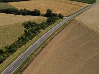 Aerial view of a landscape with agriculture fields and a asphalt road in summer 