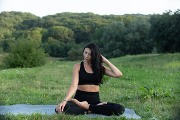 Young woman does yoga near the lake. Relax outdoor sports meditation. Wellness, summer, fitness