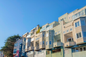 Low angle view of townhouses with wood lap siding and garden roof on roof deck