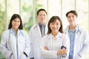 Fototapeta premium Group of Asian doctors team portrait standing with colleagues in background.
