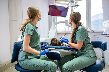 Obraz premium the dentist examine the child's teeth with a camera and display the picture on the screen.