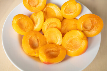 ripe, juicy apricots lie on a white plate. Energy boost, vitamins, ripe fruits, pesticides. Interruptions in the supply of fruits, imports of apricots