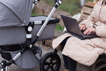 Obraz premium young caucasian mother walking with newborn baby in buggy due to coronavirus covid-19 pandemic lockdown. Business woman working online, using laptop, using social media