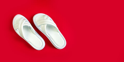 Women's summer white slippers on a red background. Slippers. Banner for insertion into site. Place for text cope space. Horizontal image
