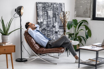 Business young man relaxing in leather chair