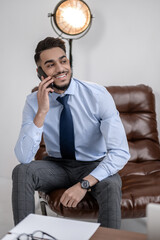 Man talking on smartphone smiling to side