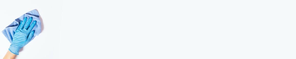 Gloved hand wipes surface with cloth