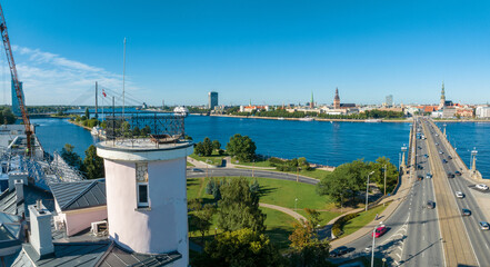 A bridge over river Daugava in Riga with a train passing by. Bridges in Latvia. Aerial Riga view.