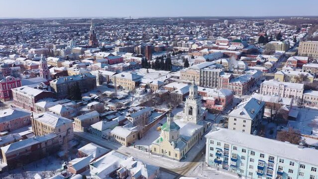Scenic aerial view of covered with snow houses and churches in Russian city of Yelets on sunny winter day, Lipetsk Oblast