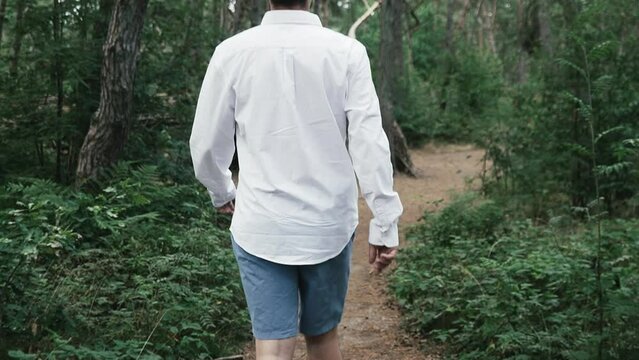 Man walking through the forest in slow motion.
