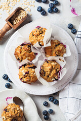 Vegan oatmeal, banana, blueberry muffins on gray background. Plant based dessert.