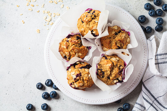 Vegan oatmeal, banana, blueberry muffins on gray background. Plant based dessert.