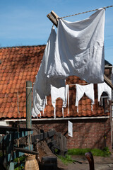 Old-fashioned laundry drying in wind on clotheslines. Walking in historical Dutch fisherman's village in North-Holland, Enkhuizen, Netherlands