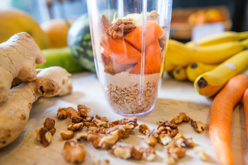 Healthy fruit shake on table with fruits and vegetables ingredients around.