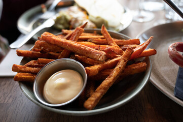 Bowl with deep fried sweet potato chips served with mayonnaise sauce