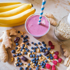 Fototapeta na wymiar Healthy fruit shake on table with fruits and vegetables ingredients around.