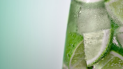 Misted glass of water with ice and lime slices