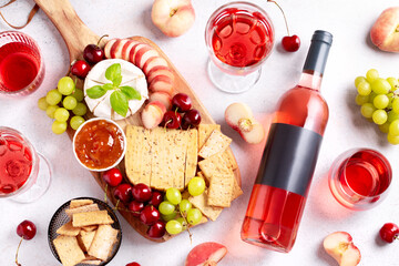 Bottle of rose wine mockup with blank label, cheese board and fruits