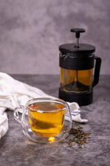 Green tea. Green tea brewed with French press on a dark background. Healthy drinks. Herbal tea concept. close up
