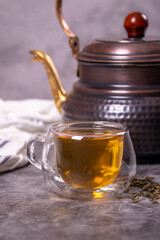 Green tea. Green tea brewed with copper teapot on dark background. Healthy drinks. Herbal tea concept. close up