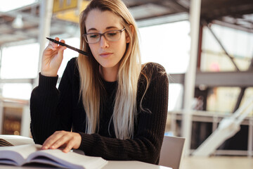 Serious female student preparing for exam in library