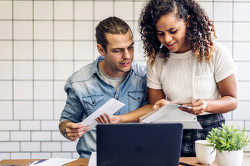 Obraz premium Happy couple use laptop computer reading documents and calculating bills to pay together.business couple hold paper bills managing account invoice at home.loan bankruptcy money concept