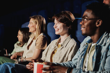 Group of cheerful multi-ethnic people spending time watching funny comedy movie at cinema