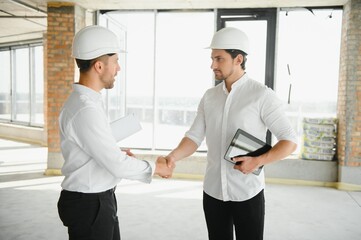 Two young man architect on a building construction site