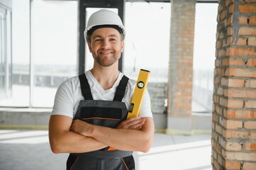 Portrait of handsome male builder in overalls and hard hat