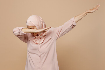 Young arabian asian muslim woman she wear abaya hijab pink clothes do dab hip hop dance move...