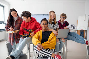 Group of students sitting and posing together in robotics classroom