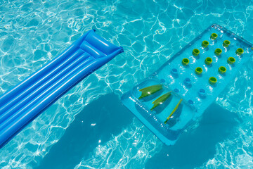 Clear blue summer pool lounger float on a rippled swimming pool