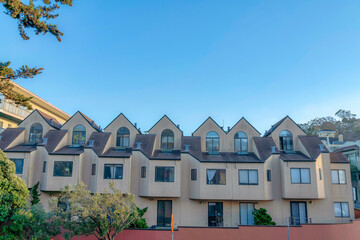 Apartment building with dormer roofs and sliding glass doors in San Francisco, California