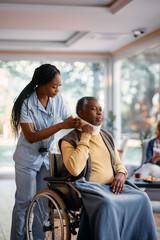 Young black nurse adjusting neck collar to elderly man at nursing home.