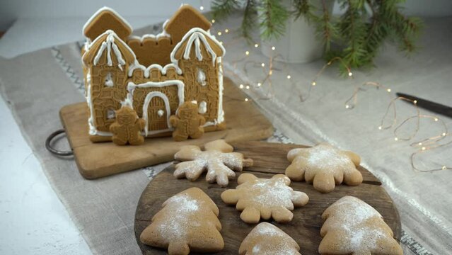 Gingerbread house Christmas homemade baking. Gingerbread Man. astle with white icing. Cookies in the shape of a Christmas tree and snowflakes on the table. Food for dessert. Winter gingerbread.