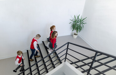 High angle view of schoolchildren in uniforms walking in school staircase.