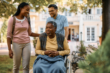 Happy black woman visiting her senior father in nursing home. - Powered by Adobe