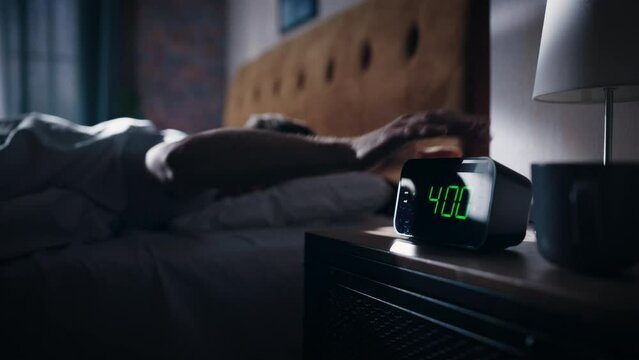 Man Wakes Up and Turns off Alarm Clock. Early Rising Productive Man Ready Start a Day full of New Adventures. Bedside Nightstand Focus on the Clock Showing Four O'Clock. Bedroom Apartment