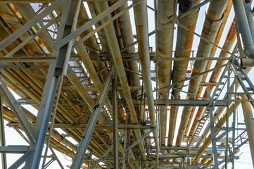 An overpass with pipes at an oil refinery. Transportation of chemical products through pipes at a chemical industry enterprise. Pipeline with dangerous chemicals.