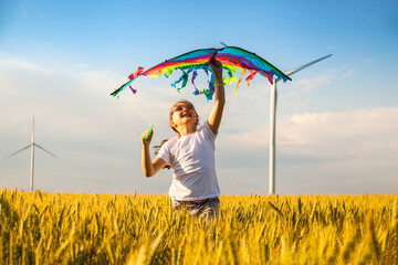 Happy Little girl running in a wheat field with a kite in the summer.