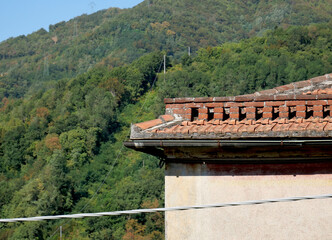 The solid brick roof of an old country house with copper gutter and external electrical wiring