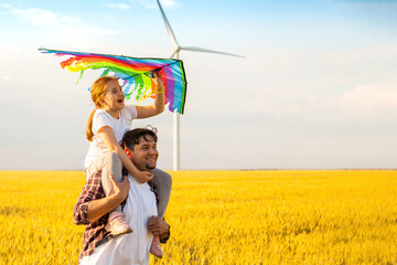 Father and daughter having fun, playing with kite together on the Wheat Field on Bright Summer day
