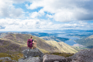girl with dog watching Scottish scenery
