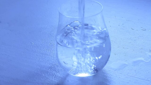glass of water sitting on table with running water stock footage