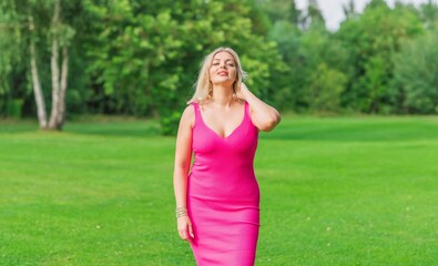 Naklejka na ściany i meble Plus size American blonde woman in pink midi dress at nature. Life of people xl size, happy nice natural beauty woman
