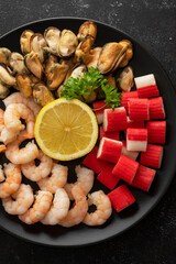 Seafood charcuterie plate board with shrimps, dark background, top view