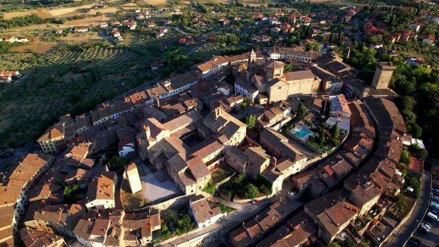Aerial Drone 4K Video of Lucignano Tuscany at Sunset Elliptical Medieval Walled Town on Hilltop near Siena Cinema Cinematic Tilt Down to Church and Rise to Valdichiana Valley Scenic Fields Italy