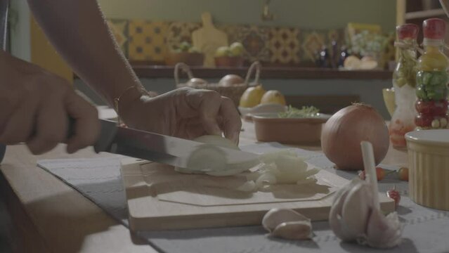 ungraded slicing onion, dicing onion in a wood cutting board, mise en place onion, handheld camera