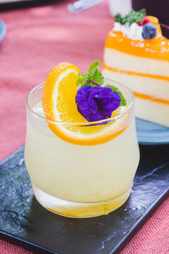 A Glass Of Japanese Iced Yuzu Fruit Tea Topped With Sliced Yuzu Orange And Mint.